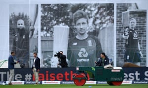 A Groundsman works on the outfield as Ian Ward and Michael Atherton of Sky Sports looks on.