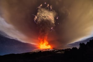 The night sky lights up over the east coast of Sicily as Mount Etna’s Voragine crater erupts for the first time in two years