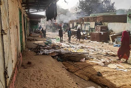 People walk among the wrecked market of El Geneina, the capital of West Darfur.