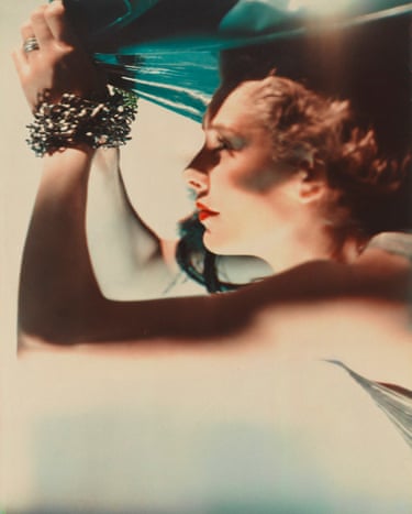 Mrs Richard Hart-Davis, as Ariel, raises her bangled arm holding teal fabric overhead