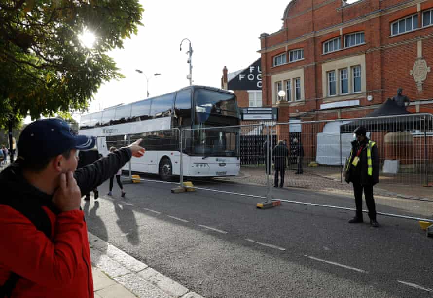 Fans pass by team buses parked outside Fulham’s Craven Cottage before the game against Everton on 22 November.