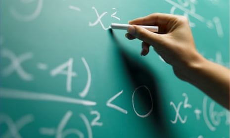 A teacher writing on a chalkboard.