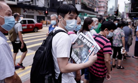 A Hong Kong resident grabs a copy of the last issue of Apple Daily in Hong Kong after its forced closure.