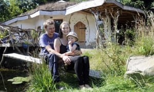 Charlie Hague, Megan Williams and their child outside their house.