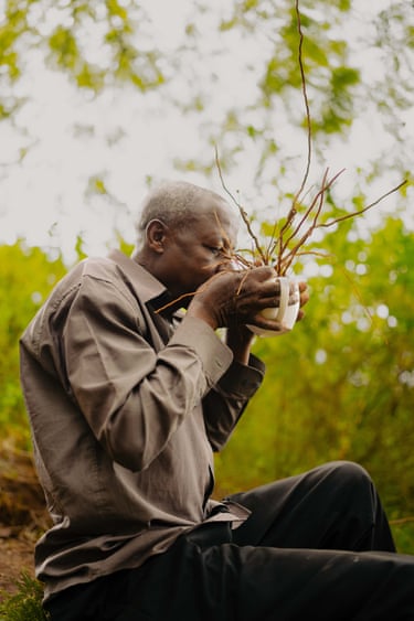 man smelling bunch of twigs