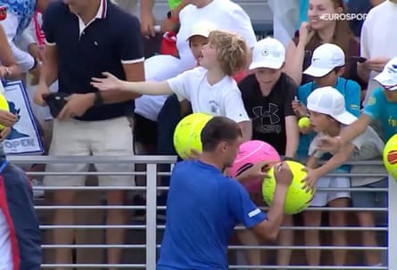 A man is seen on camera grabbing a baseball cap from a boy after Kamil Majchrzak signed it at the US Open in August.
