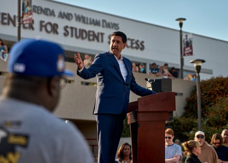 a man speaks on an outdoor stage