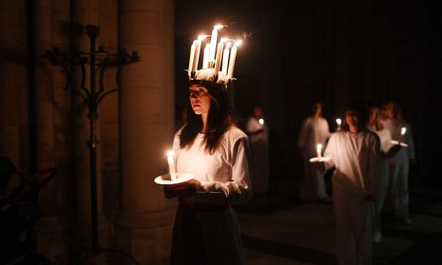 Candlelit procession led by a young woman in the role of St Lucia, at York Minster's Swedish Lucia Festival of Light, held this year on 3 December.