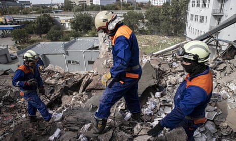 Firefighters remove debris from a bombed-out printing factory in Kharkiv.