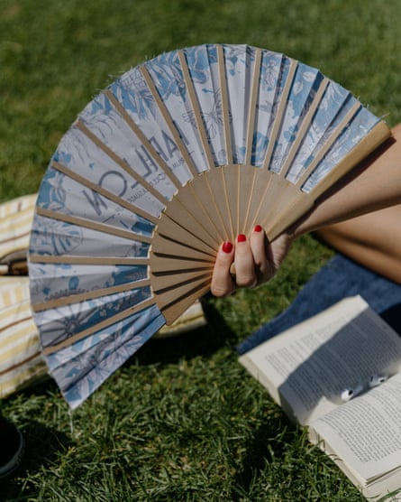 A woman fans herself while sunbathing on the square.