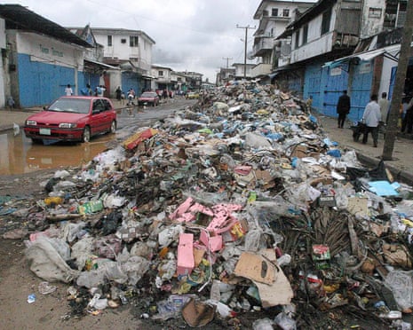 Liberians pass rubbish dumped in the streets of the capital, Monrovia.