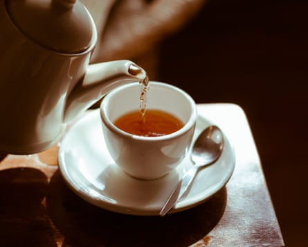 Pouring hot tea into a white ceramic teacup