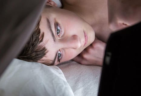 Teenage boy using a digital tablet at night.