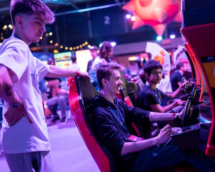Some visitors play in a racing simulator game.