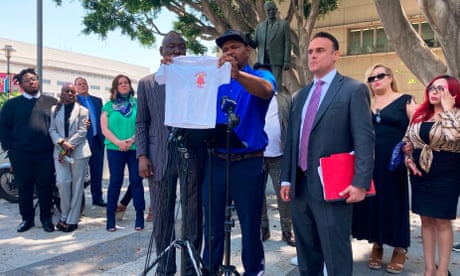 Man holds up T-shirt at press conference