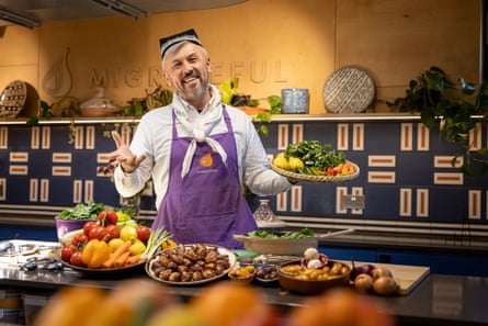 A chef presents an array of colourful dishes at a Migrateful cooking class.