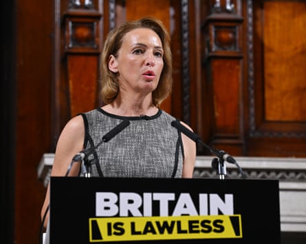 Reform UK MP Sarah Pochin speaking at a press conference with wording on a podium reading ‘Britain is lawless’