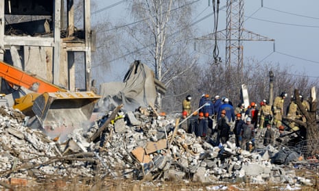 Workers remove debris of a building used as temporary accommodation for Russian soldiers, 89 of whom were killed in a Ukrainian missile strike on 1 January 2023. 