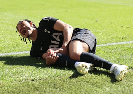 Xavi Simons of Tottenham screams in agony as he clutches his injured knee