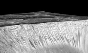 Dark narrow streaks called recurring slope lineae emanate out of the walls of Garni crater on Mars.