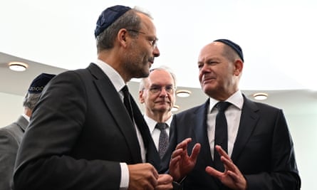Felix Klein speaks with the German chancellor, Olaf Scholz, both wearing kippah head coverings, dark suits, white shirts and black ties