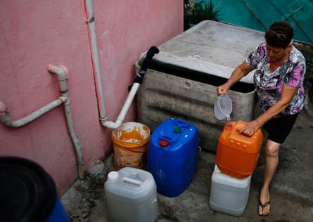 A resident of São Paulo’s Brasilandia neighbourhood prepares rainwater to use in the bathroom and to clean the floor of her house.