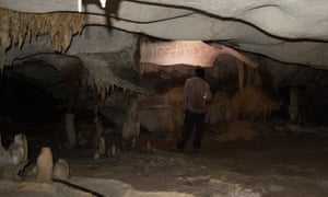 A researcher looks at drawings in a cave on Mona island