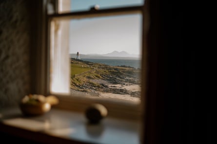 View of the sea, a distant island and a lighthouse through a window