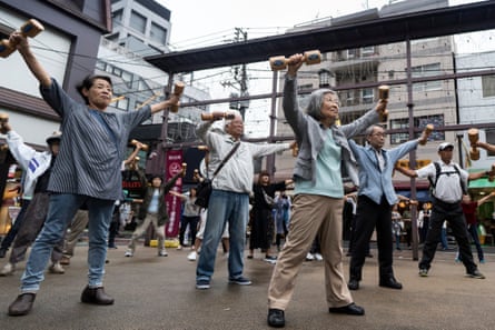 People exercise with wooden dumbbells during an event marking Respect for the Aged Day in Tokyo.