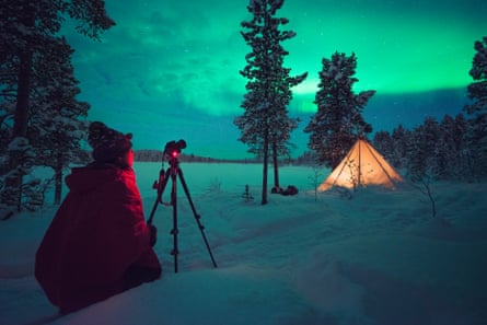 Taking photo of the northern lights in the snow, with Scandinavian Photo Adventures