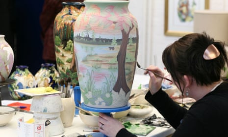 A worker at the Moorcroft Pottery in Stoke-on-Trent demonstrates the intricate skill of vase painting.