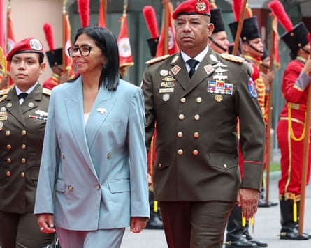 Delcy Rodriguez walks along a guard of honour with people in military uniform behind her.