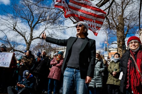 Man holds flag that says We the People.