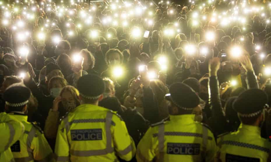 Police officers face the crowd during a vigil for Sarah Everard in Clapham Common