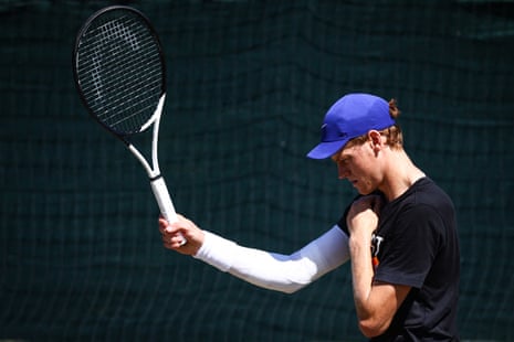 Jannik Sinner limbers sore arm.