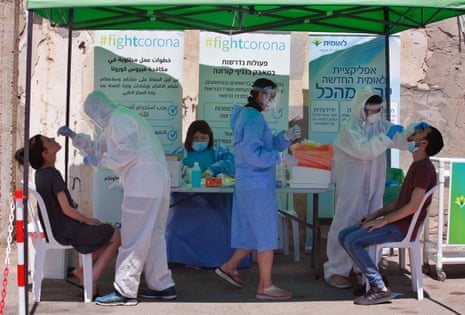 Medical workers take samples from citizens for Covid-19 test in the central Israeli city of Lod on 2 July, 2020.