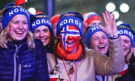 Close up of a group of female Norwegians at a ski event, with faces painted in the colours of the Norwegian flag.