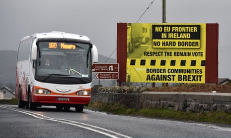 A bus crossing along the border between Northern Ireland and the Republic of Ireland passes a sign campaigning against a hard Brexit.