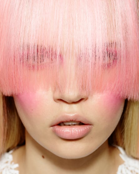 Closeup of girl’s face with long pink fringe covering her eyes