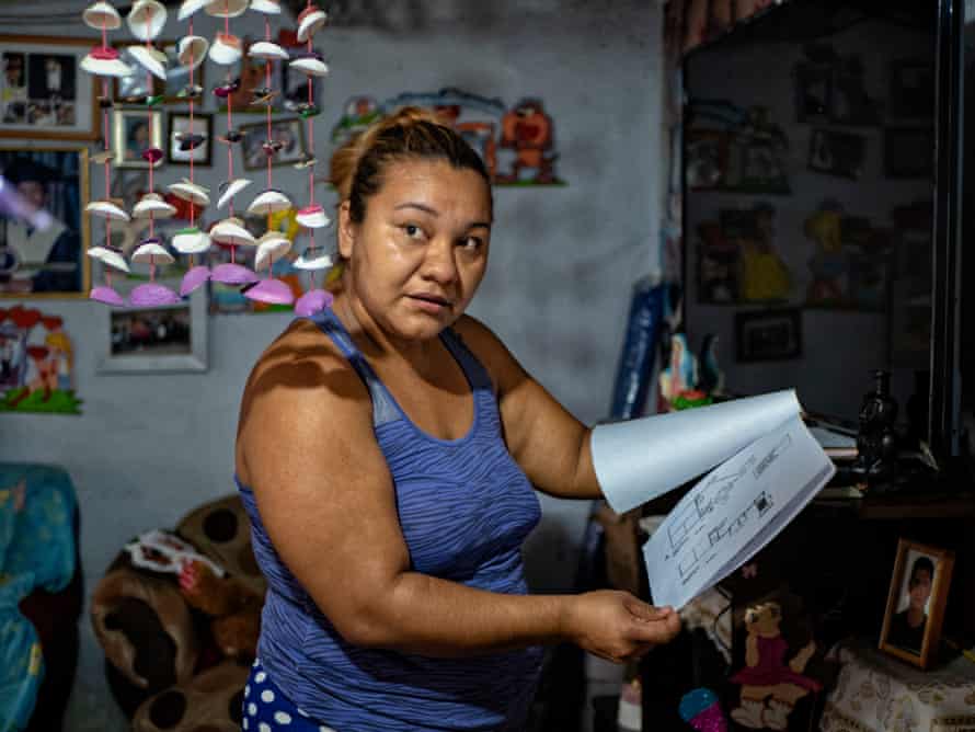 Esmeralda shows the drawings of how to build a home sewage system, which is what the Salvadoran water department is requiring for residents to have if they wish to be considered to have a potable water system in their home.