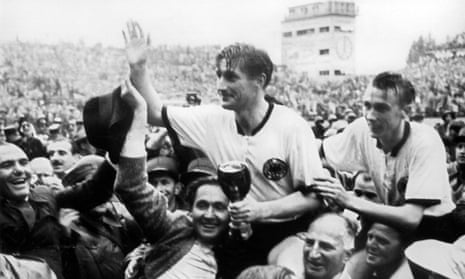 Fritz Walter, holding the Jules Rimet trophy, and Horst Eckel, right, are carried on the shoulders of their fans after the final.