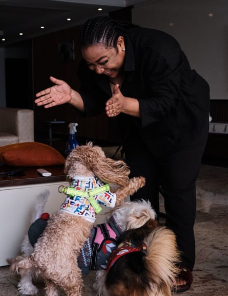 An African woman laughing as she plays with small dogs
