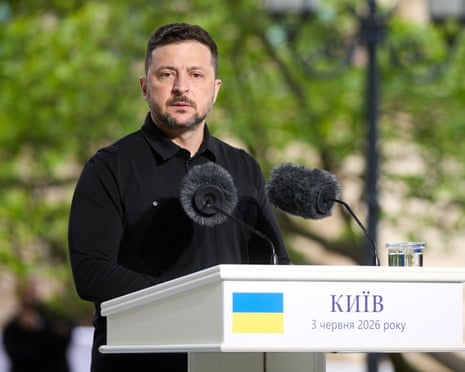 President Zelenskyy speaks at a podium with microphones and the Ukrainian flag