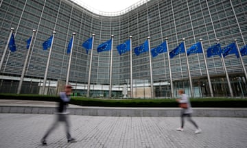 People walk past the EU headquarters in Brussels