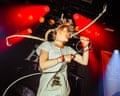Taylor Zantingh singing into a microphone under red stage lights