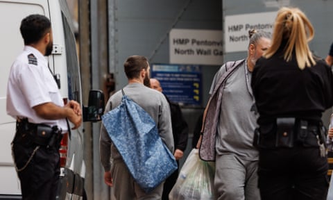 people carrying plastic bags of belongings in front of HMP Pentonville