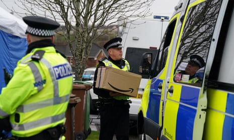 An officer from Police Scotland carries a parcel delivery into the home of former chief executive of the Scottish National party (SNP) Peter Murrell in Glasgow.