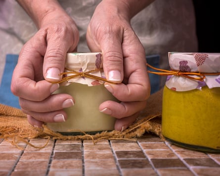 Image of a person tying the top on a jar of curd