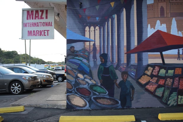 A mural depicting scenes of traditional Kurdish life is painted on the side of a Kurdish grocer in Little Kurdistan, Nashville.