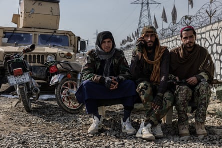 Taliban fighters sit by the roadside in Logar’s Mohammad Agha district
